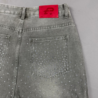 Gray jeans with rhinestone embellishments on a gray background