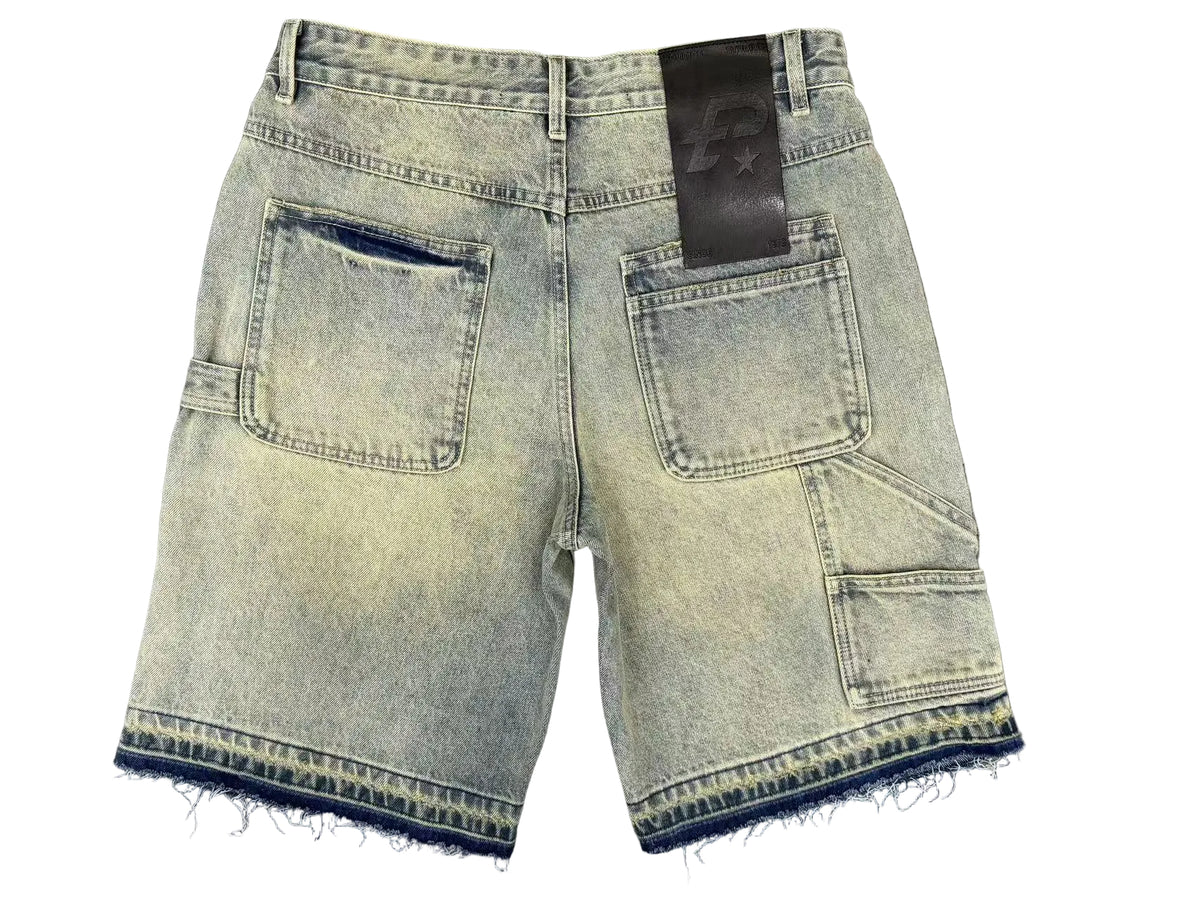 Light blue denim shorts with a black label on a gray textured background
